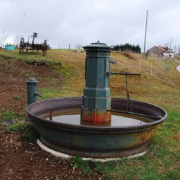 Saint-Laurent-en-Grandvaux, nov 2009 F. Leng / CAUE39 : Fontaine à corps octogonal en fonte terminée par un toit circulaire plat, surmonté d'une pomme de pain. Les faces sont ornées de symbolisation de flambeaux. Le bassin circulaire en fonte est signé VARIGNEY (fonderie en Haute-Saône) - SAINT-LAURENT-EN-GRANDVAUX (39150)